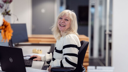 Lachende mevrouw achter laptop